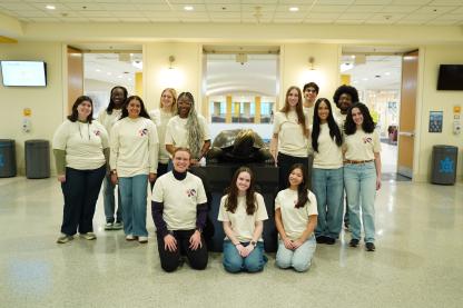 group of students posing by Testudo statue in matching beige shirts