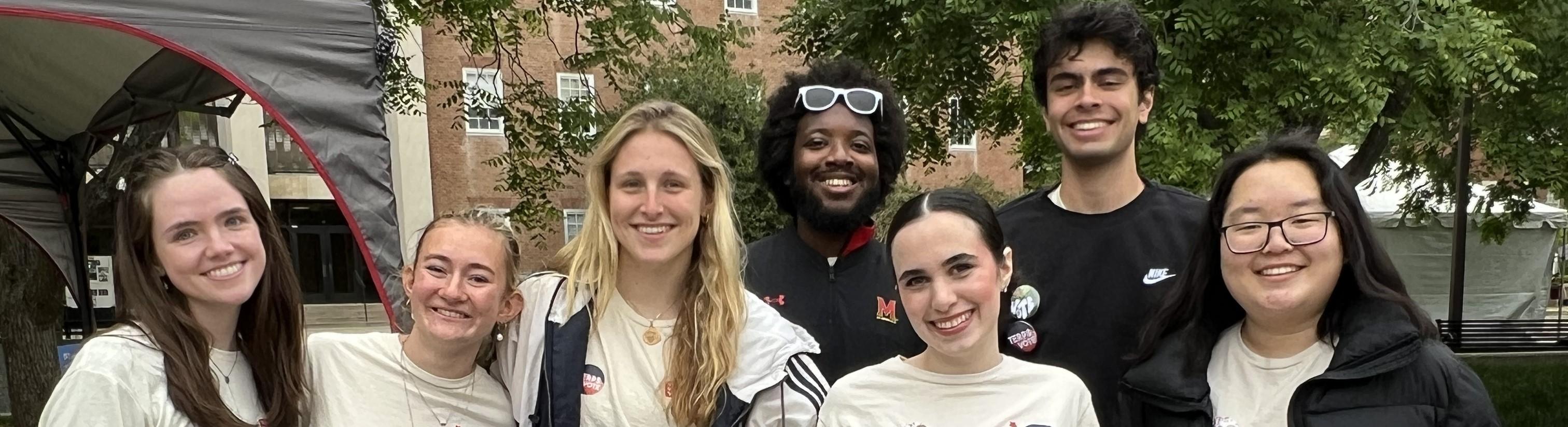 group of terpsvote students in matching shirts standing and smiling at camera outdoors